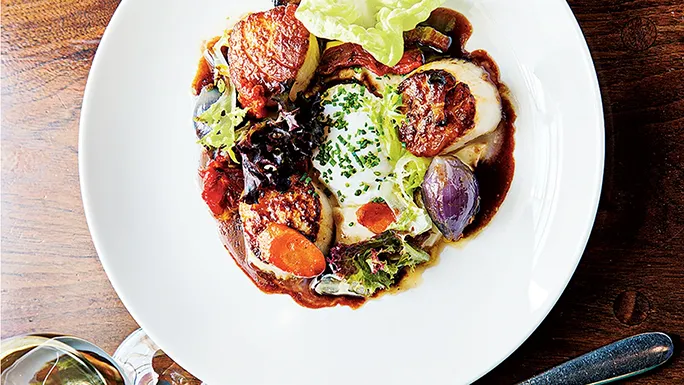 A plated dish in a dimly lit, intimate dining room